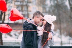 Verliebtes Paar mit roten Herz-Luftballons, die ihrer Liebe eine Chance gegeben haben und es geschafft haben, ihre Beziehungskrise zu meistern.