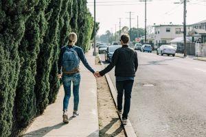 Ein Paar, das einen Weg entlang läuft und sich an der Hand hält. Ob die beiden wohl ein ausgewogenes Verhältnis von Nähe und Distanz in ihrer Beziehung haben?