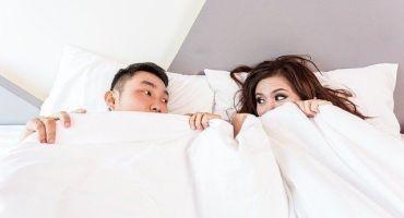 Ein Paar liegt zugedeckt im Bett. Sex ist nach vor oft ein Tabuthema in Beziehungen. Paare können oft nicht über Sex reden.