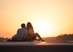 Ein Paar sitzt entspannt auf einer Mauer und genießt den Sonnenuntergang, die Nähe, die Zuwendung, die Wärme und Liebe. Eine gute Möglichkeit, sich gegenseitig die Wünsche und Bedürfnisse in der Partnerschaft mitzuteilen Ein Paar sitzt entspannt auf einer Mauer und genießt den Sonnenuntergang, die Nähe, die Zuwendung, die Wärme und Liebe. Eine gute Möglichkeit, sich gegenseitig die Wünsche und Bedürfnisse in der Partnerschaft mitzuteilen