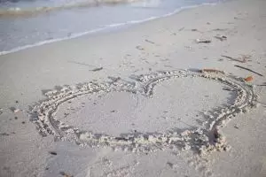 Ein Herz im Sand gezeichnet von einem Paar, dass die Liebe im Alltag bewahren konnte.