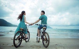 Paar mit Fahrrad am Strand. Gemeinsame Ziele und Visionen in der Partnerschaft lassen in die gleiche Richtung blicken.
